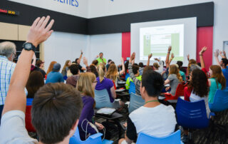 Students raising hands at Mission Fed JA Finance Park classroom