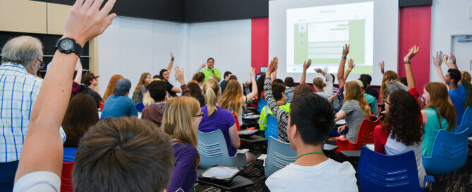 Students raising hands at Mission Fed JA Finance Park classroom