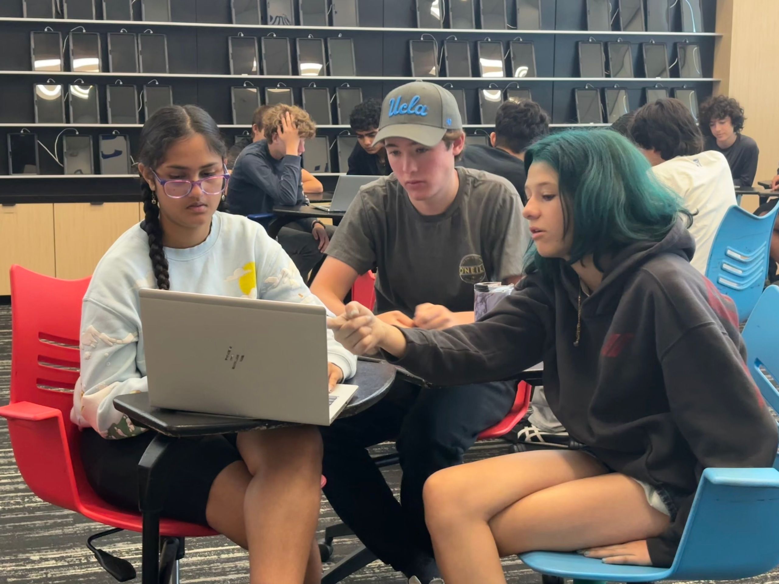 Three students working on laptop