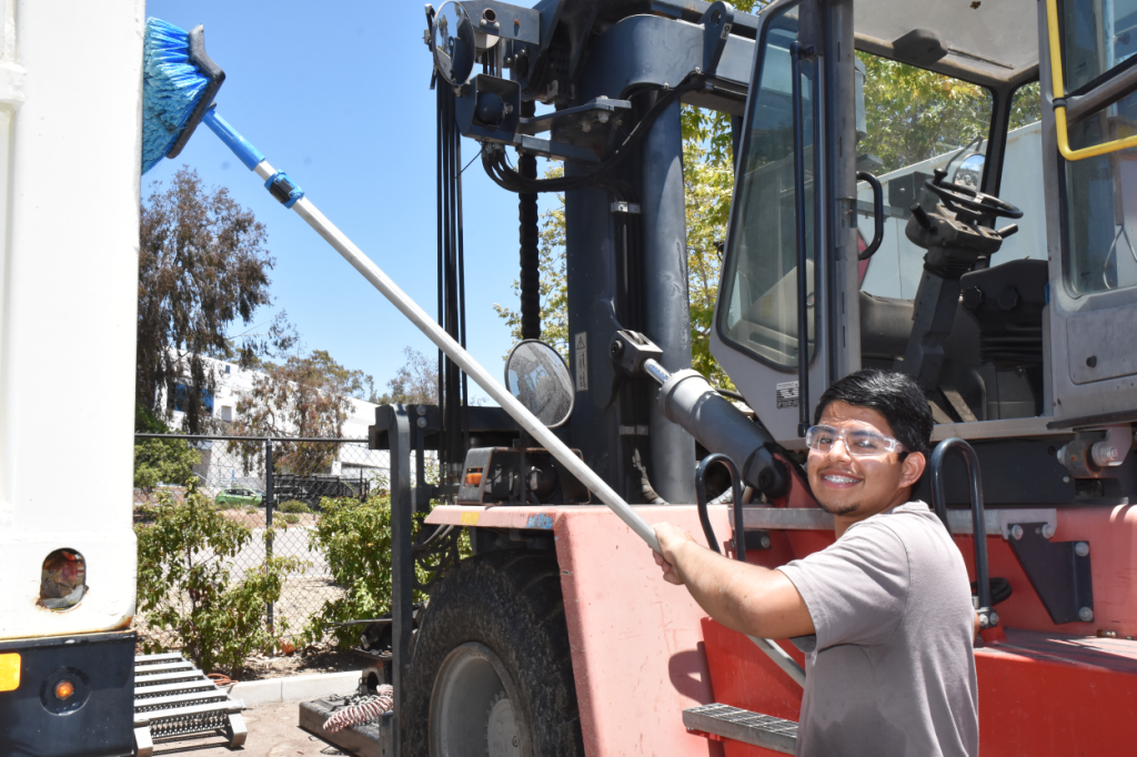 Student intern cleaning machinery
